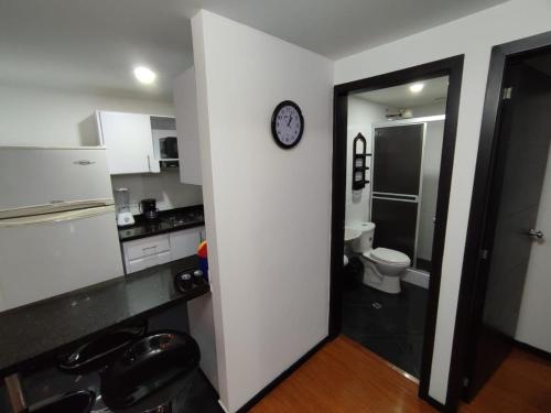 a kitchen with a toilet and a clock on the wall at Céntrico luminoso y equipado apto in Pasto