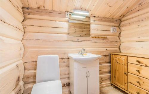 La salle de bains est pourvue de toilettes et d'un lavabo dans une cabane en rondins. dans l'établissement Beautiful Home In Dalholen With House A Mountain View, à Furuhovde