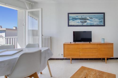 - un salon avec une télévision et une commode en bois dans l'établissement Bright 60m near the beach, à Six-Fours-les-Plages