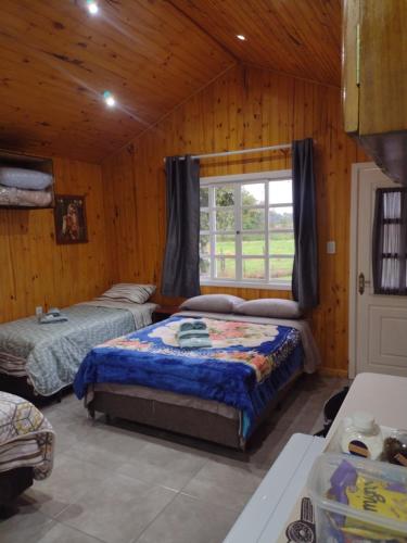 1 Schlafzimmer mit 2 Betten und einem Fenster in der Unterkunft Pousada das Palmeiras in Pelotas