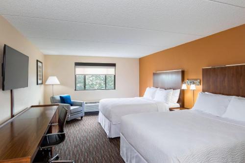 a hotel room with two beds and a television at Four Points by Sheraton Milwaukee Airport in Milwaukee