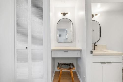 a bathroom with white cabinets and a mirror and a stool at *Remodeled Oceanfront in Waikiki - Ilikai Marina in Honolulu