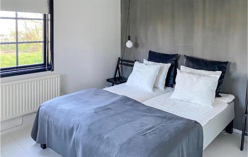 sypialnia z dużym łóżkiem z niebieską pościelą i poduszkami w obiekcie Gorgeous Home In Skivarp With Kitchen w mieście Skivarp