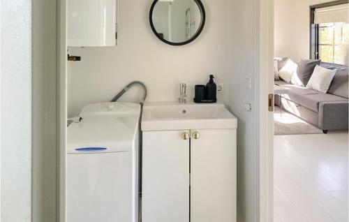 W białej łazience znajduje się umywalka i lustro. w obiekcie Gorgeous Home In Skivarp With Kitchen w mieście Skivarp