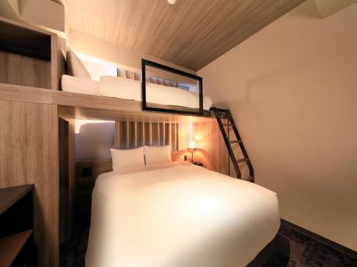 a bedroom with a bed in a small room at QuintessaHotel FukuokaHakata Relax&Sleep in Fukuoka