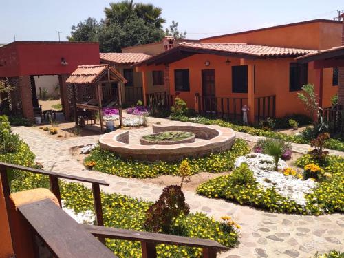 un jardín frente a una casa con una fuente en Villas Rincón del Paraíso, en Las Palmas