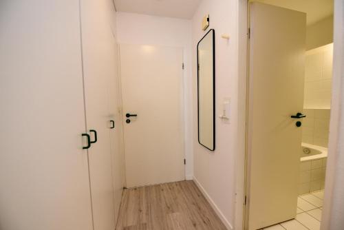 baño con puerta blanca y espejo en Haus "Hohe Worth" Appartement HW103, en Duhnen