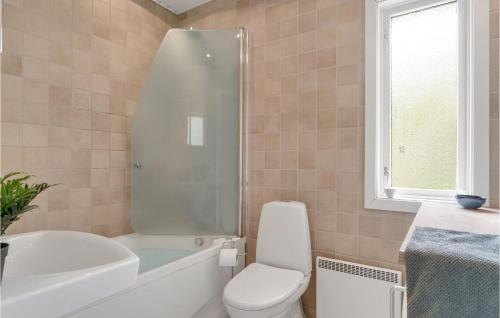 a bathroom with a toilet and a tub and a sink at 2 Bedroom Pet Friendly Home In Hornbk in Hornbæk