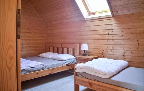 two beds in a log cabin with a window at Stunning Home In Sianozety With Wifi And 2 Bedrooms in Sianozety