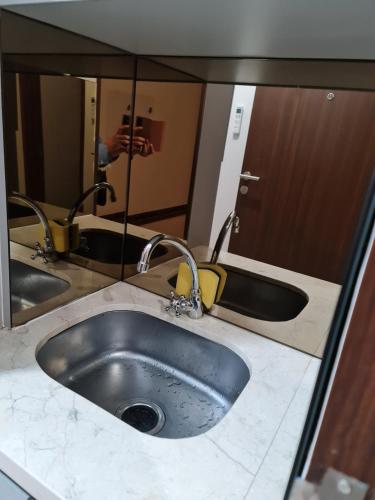 lavabo con 2 grifos y espejo en Apartemen transpark cibubur by parvez, en Kalimanggis