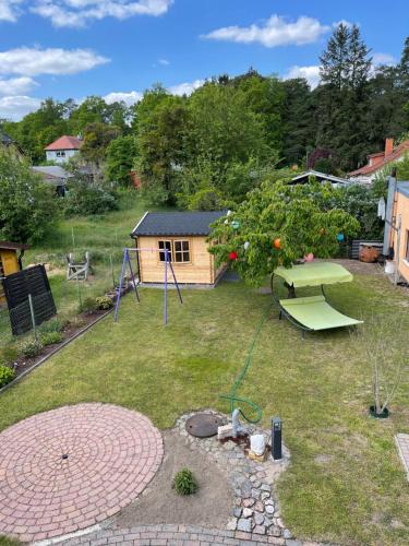 um jardim com uma mesa de piquenique e um parque infantil em Oase der Ruhe em Waldsieversdorf