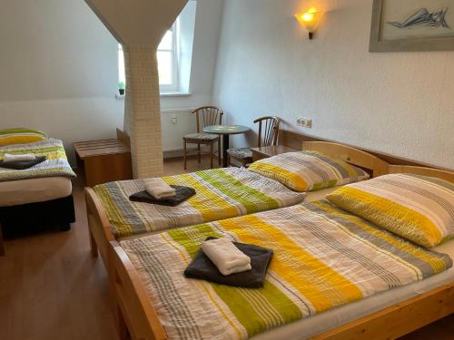 two beds in a room with towels on them at Pension Markt Neustrelitz in Neustrelitz