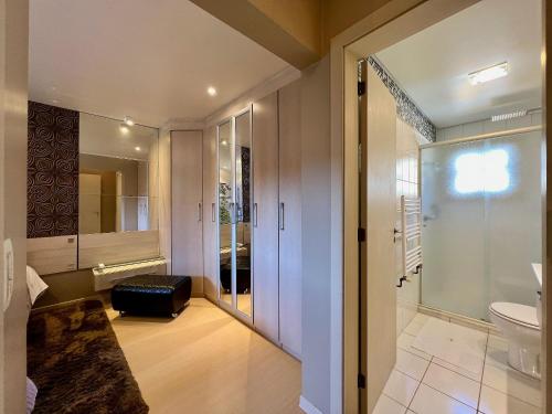 a bathroom with a toilet and a glass door at Cobertura Duplex de Cinema 3dorm by Achei Gramado in Gramado