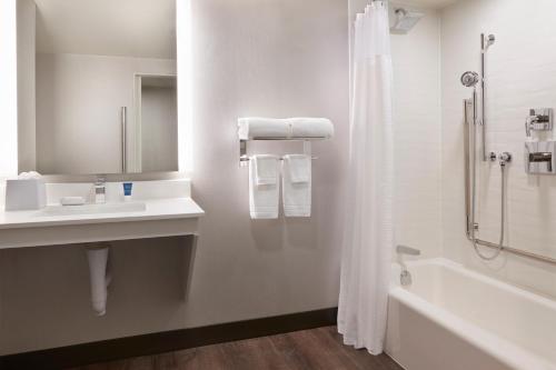 a bathroom with a sink and a tub and a shower at Four Points by Sheraton Windsor Downtown in Windsor