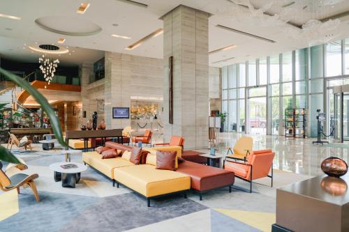 a lobby with a couch and chairs in a building at Holiday Inn Guangzhou Science City, an IHG Hotel in Guangzhou