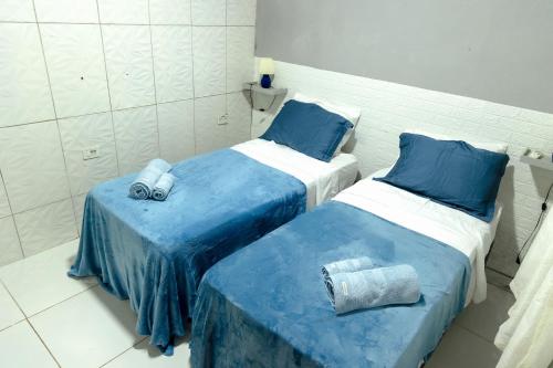two beds sitting next to each other in a room at Noronha Economy Suítes - Hospedagem com melhor localização e custo benefício da ilha in Fernando de Noronha