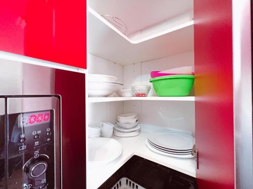 プラヤ・デ・ラス・アメリカスにあるModern studio in complex Paraiso Royal, LA95の赤いキッチン(白い皿、食器付)