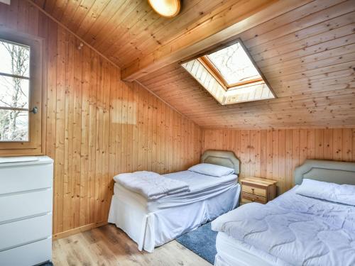 Cette chambre en bois dispose de 2 lits et d'une lucarne. dans l'établissement Chalet Herisson - 9 pers - À 100m du Lac des Ecoles et 300m des pistes - FR-1-685-68, aux Gets