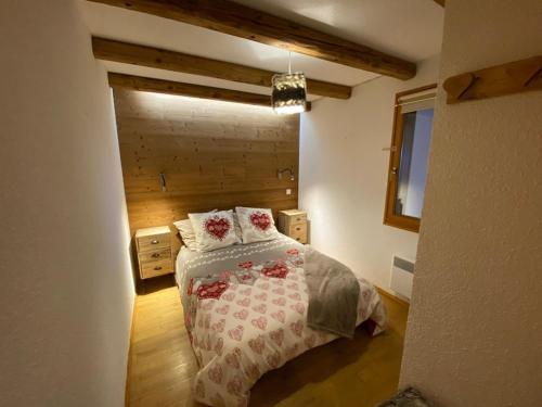 - une chambre avec un lit et un mur en bois dans l'établissement Appartement pour 4 pers. terrasse, proche centre et pistes, parking garage - FR-1-733-60, à Crest-Voland