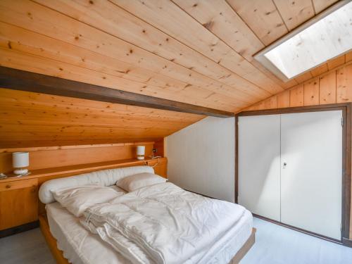 un lit dans une chambre avec un plafond en bois dans l'établissement Appartement cosy 4-6 pers, balcon, au pied des pistes, proche centre et école de ski, garage inclus - FR-1-684-62, à Morzine