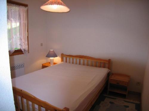 ein Schlafzimmer mit einem großen Bett mit einer weißen Tagesdecke in der Unterkunft Appartement Crest-Voland, 3 pièces, 6 personnes - FR-1-733-15 in Crest-Voland