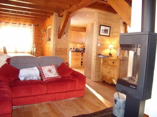 un salon avec un canapé rouge et une télévision dans l'établissement Chalet 8 pers. à 350m des pistes, 4 ch., WiFi, garage, poêle à bois, ensoleillé, Crest-Voland - FR-1-733-37, à Crest-Voland