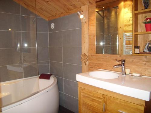 ein Badezimmer mit einer Badewanne, einem Waschbecken und einer Badewanne in der Unterkunft Chalet Crest-Voland, 6 pièces, 8 personnes - FR-1-733-37 in Crest-Voland