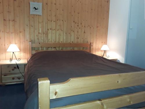 a bedroom with a wooden bed with two lamps at Duplex cosy 3 pièces pour 6 pers. à Crest-Voland, balcon, proche des pistes et commerces - FR-1-733-58 in Crest-Voland