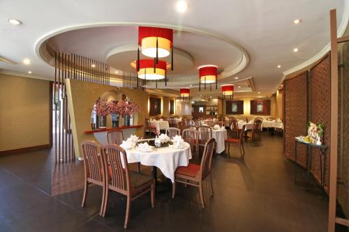 a restaurant with white tables and chairs and red chandeliers at The Imperial Hotel & Convention Centre Korat in Nakhon Ratchasima