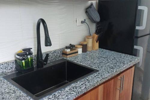 a kitchen counter with a sink and a refrigerator at Beautiful sea front apartment in Paraíso