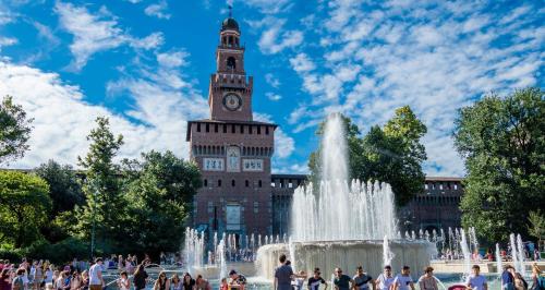 a building with a clock tower in front of a fountain at Holiday Inn Milan Nord Zara by IHG in Cinisello Balsamo