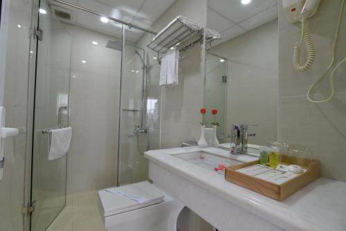 a bathroom with a shower and a sink and a toilet at Blue Hanoi Inn Hotel in Hanoi