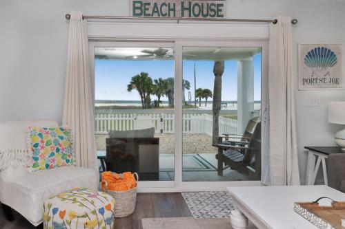 a living room with a porch with a beach house sign at Stay Salty in Saint Joe Beach