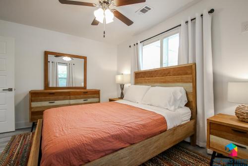 ein Schlafzimmer mit einem Bett, einem Spiegel und einem Deckenventilator in der Unterkunft Perchcozy, Quiet Home Close To Sav, I-95 Pets in Savannah