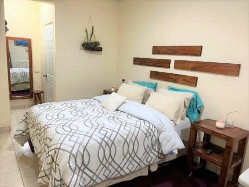 1 dormitorio con 1 cama grande y cabecero de madera en COMFY. Full internet, kitchen, washer and dryer, Netflix, en Chimaltenango
