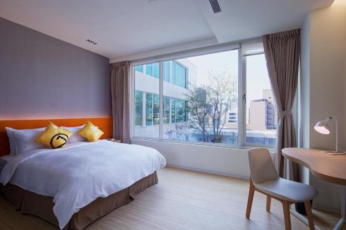 a bedroom with a bed and a large window at Hotel 7 Taichung in Taichung