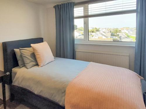 a bedroom with a bed and a window with a view at Harbour Heights in Brixham