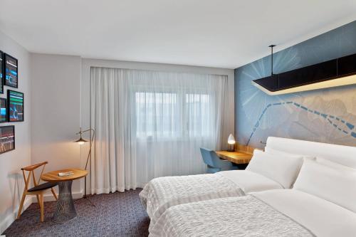 a hotel room with a bed and a desk at Le Méridien Paris Arc De Triomphe in Paris