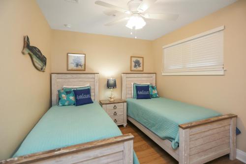 a bedroom with two twin beds and a ceiling fan at Club at Mexico Beach 2D in Mexico Beach