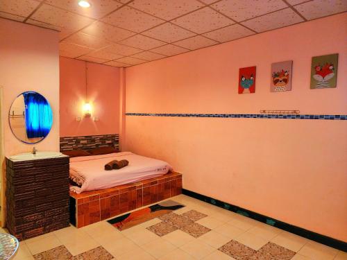 a room with a bed and a mirror and a sink at Ingpha Room For Rent in Satun