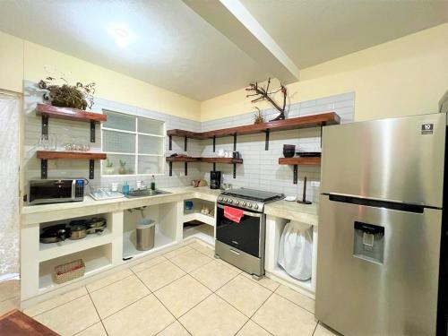 a large kitchen with a stainless steel refrigerator at COMFY. Full internet, kitchen, washer and dryer, Netflix in Chimaltenango