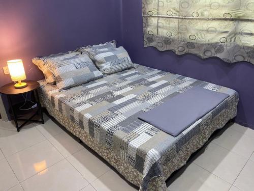 a bed in a room with a lamp on a table at SS de’ Kelulut Homestay in Marang
