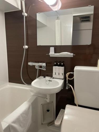 y baño con lavabo, aseo y espejo. en Orange Inn Sendaihigashi en Sendai