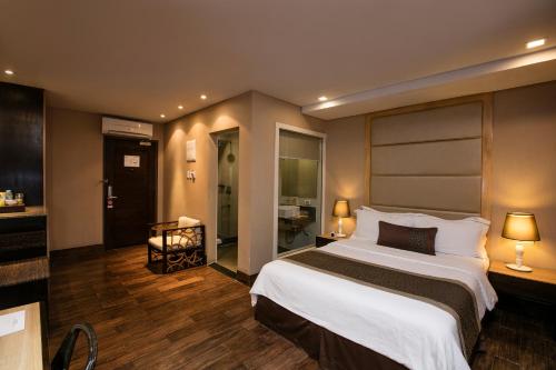 Habitación de hotel con cama grande y baño. en Goldberry Suites and Hotel - Mactan en Isla de Mactán