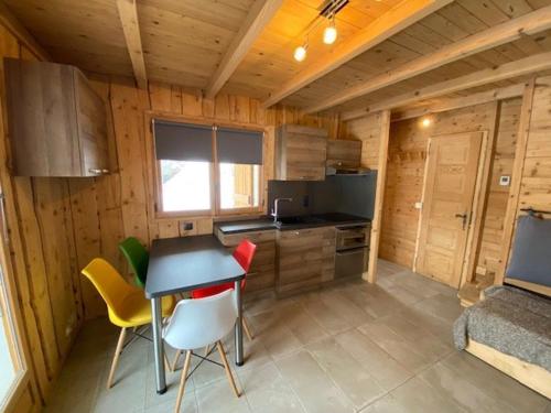 une cuisine avec une table et des chaises dans une cabine dans l'établissement Studio 4 pers. rénové, proximité pistes & commerces, balcon/terrasse, parking privé - FR-1-733-98, à Crest-Voland