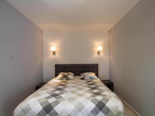 - une chambre avec un lit en damier et 2 oreillers dans l'établissement Gîte Le Bugue, 2 pièces, 2 personnes - FR-1-616-289, au Bugue