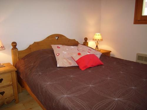 une chambre avec un lit avec deux oreillers dessus dans l'établissement Appartement cosy 1 chambre, 4 pers, centre station, 100m des pistes, balcon, bien équipé - FR-1-733-107, à Crest-Voland