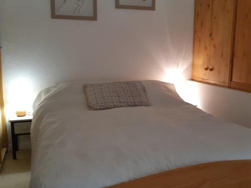 ein weißes Bett mit einem Kissen darüber in der Unterkunft Studio Crest-Voland, 1 pièce, 4 personnes - FR-1-733-111 in Crest-Voland
