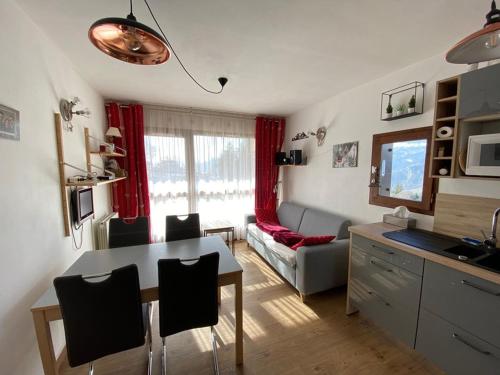 une cuisine et un salon avec une table et un canapé dans l'établissement Appartement 4 pers, rez-de-jardin, près des pistes, parking, animaux acceptés - FR-1-733-117, à Crest-Voland