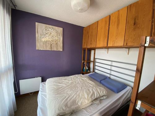 - une chambre avec des lits superposés et un mur violet dans l'établissement Appartement 4 pers, rez-de-jardin, près des pistes, parking, animaux acceptés - FR-1-733-117, à Crest-Voland